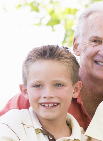 Großvater und Enkel lächeln für ein Familienbild in die Kamera